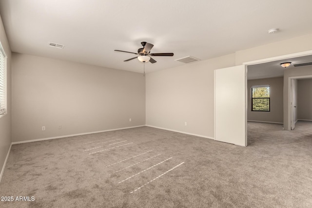 carpeted spare room featuring ceiling fan