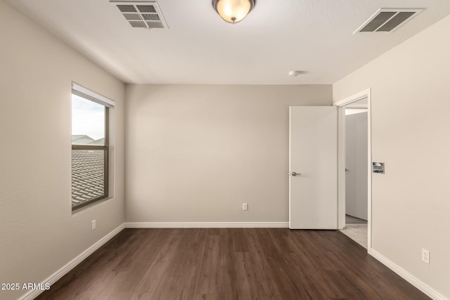 spare room with dark wood-type flooring