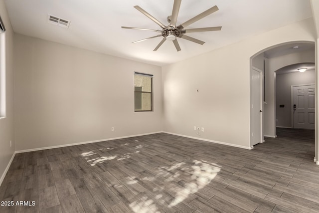 empty room featuring dark wood-type flooring and ceiling fan