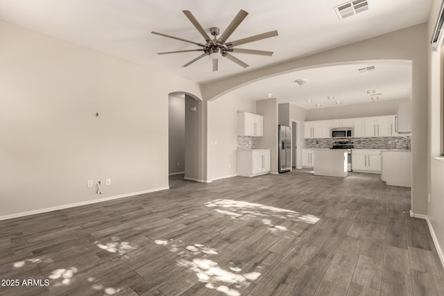 unfurnished living room featuring ceiling fan, dark hardwood / wood-style floors, and sink