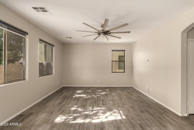 empty room with dark hardwood / wood-style flooring and a wealth of natural light