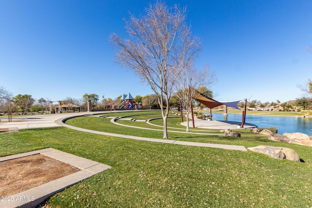 surrounding community featuring a yard, a playground, and a water view