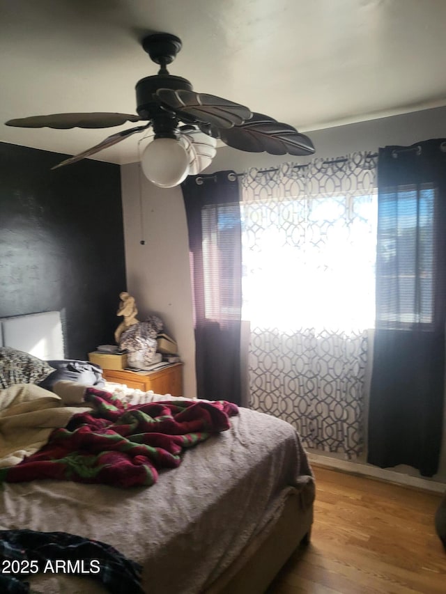 bedroom with hardwood / wood-style flooring and ceiling fan