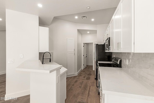 2019 E Campbell Ave Unit 110, Phoenix, AZ 85016 - kitchen featuring stainless steel appliances, wood finished floors, white cabinets, a peninsula, and tasteful backsplash