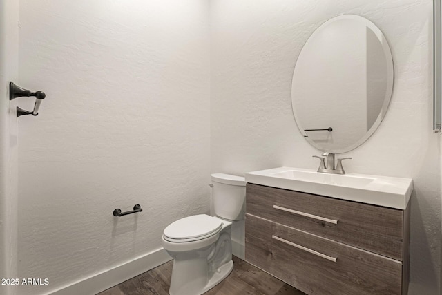 2019 E Campbell Ave Unit 110, Phoenix, AZ 85016 - half bathroom featuring wood finished floors, toilet, vanity, baseboards, and a textured wall