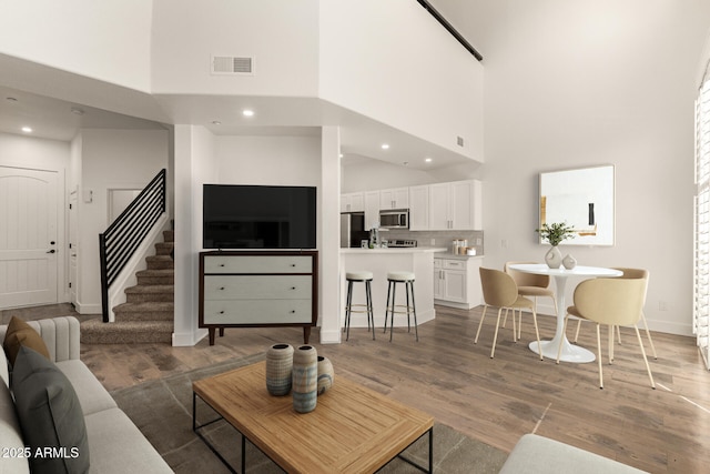 2019 E Campbell Ave Unit 110, Phoenix, AZ 85016 - living room with a high ceiling, wood finished floors, stairway, baseboards, and recessed lighting