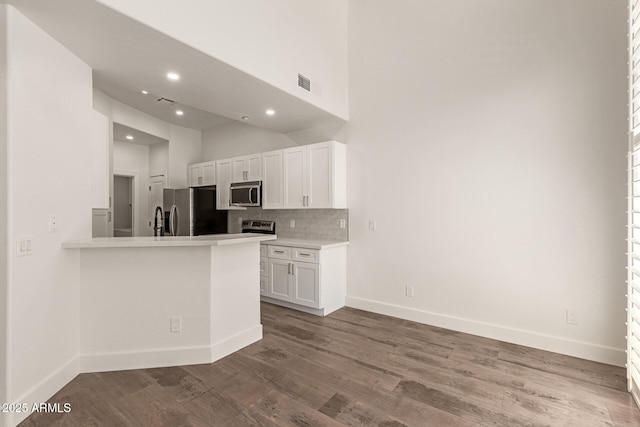 2019 E Campbell Ave Unit 110, Phoenix, AZ 85016 - kitchen featuring appliances with stainless steel finishes, white cabinets, baseboards, light countertops, and backsplash