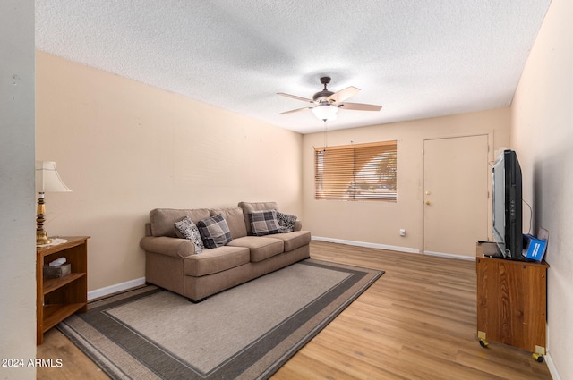 living room featuring ceiling fan, hardwood / wood-style floors, and a textured ceiling