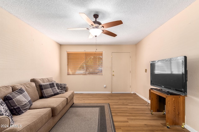 living room with a textured ceiling, wood-type flooring, and ceiling fan