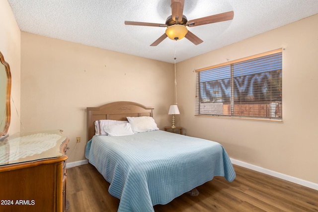 bedroom featuring a textured ceiling, dark hardwood / wood-style floors, and ceiling fan