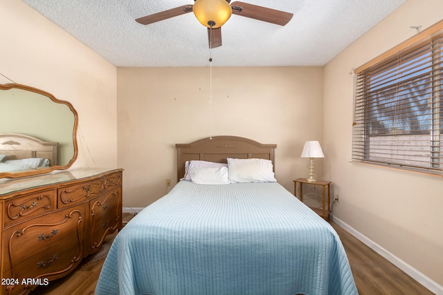 bedroom with ceiling fan, dark hardwood / wood-style floors, and a textured ceiling