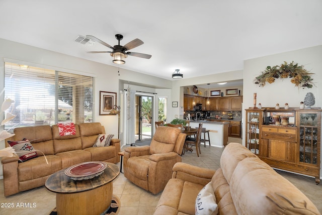 living room featuring ceiling fan, visible vents, and light tile patterned flooring