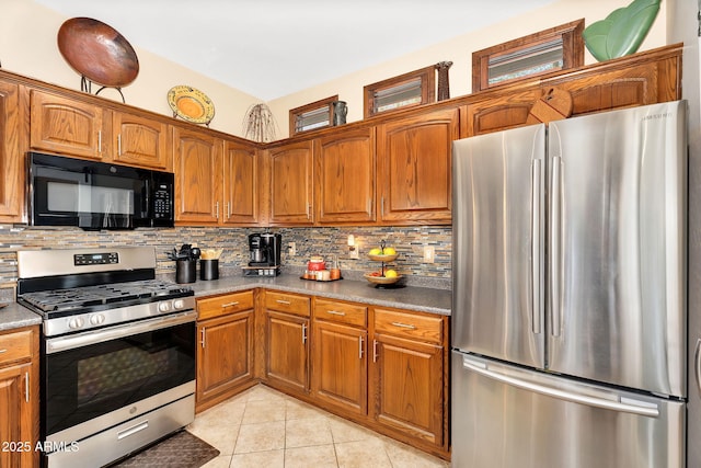 kitchen with brown cabinetry, decorative backsplash, and stainless steel appliances