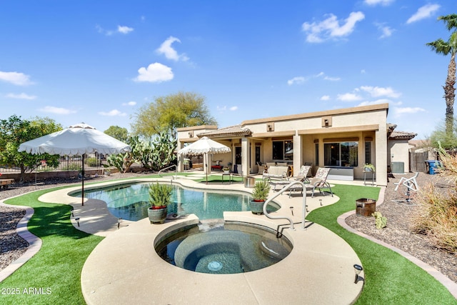 view of swimming pool with a patio area, a pool with connected hot tub, and fence