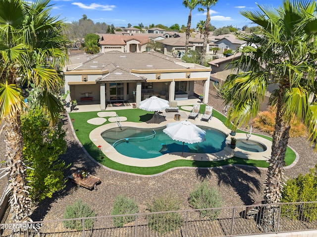 view of pool with a patio area, a pool with connected hot tub, and a fenced backyard