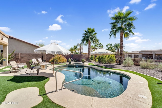 view of pool with a fenced backyard, a pool with connected hot tub, and a patio