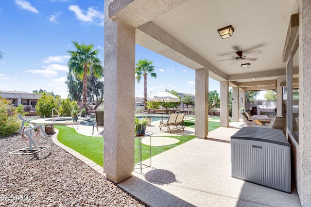 view of patio featuring an outdoor pool, ceiling fan, and fence