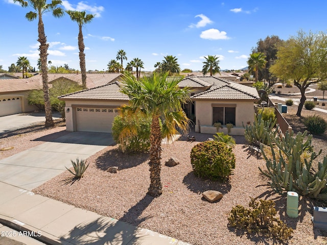 view of front of home with a tile roof, stucco siding, concrete driveway, and a garage