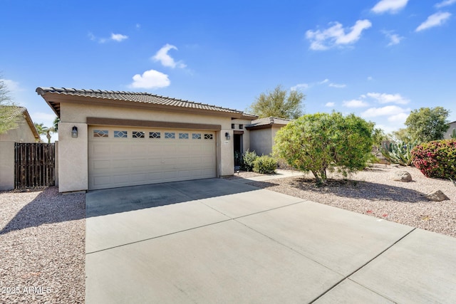 view of front of house with stucco siding, a tiled roof, concrete driveway, and a garage