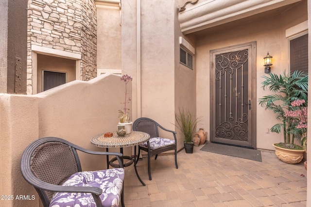 view of exterior entry featuring stone siding and stucco siding