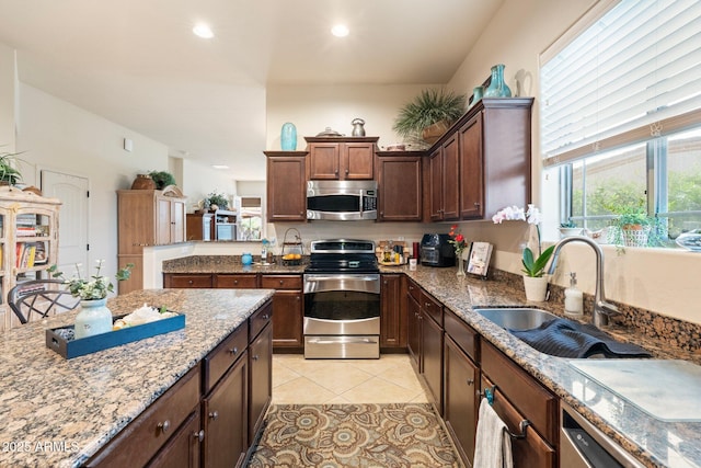 kitchen featuring light tile patterned floors, recessed lighting, a sink, appliances with stainless steel finishes, and light stone countertops