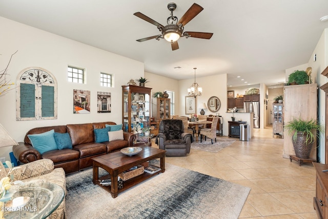 living area featuring light tile patterned floors and ceiling fan with notable chandelier