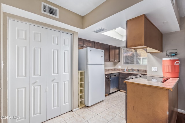 kitchen featuring kitchen peninsula, dishwasher, light tile patterned floors, white fridge, and sink