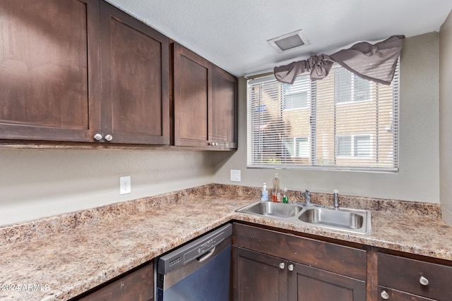 kitchen featuring a textured ceiling, dark brown cabinetry, stainless steel dishwasher, and sink