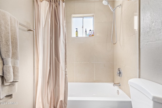 bathroom featuring shower / bath combo and toilet