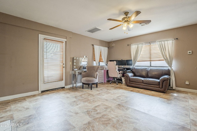 living area with ceiling fan, visible vents, and baseboards