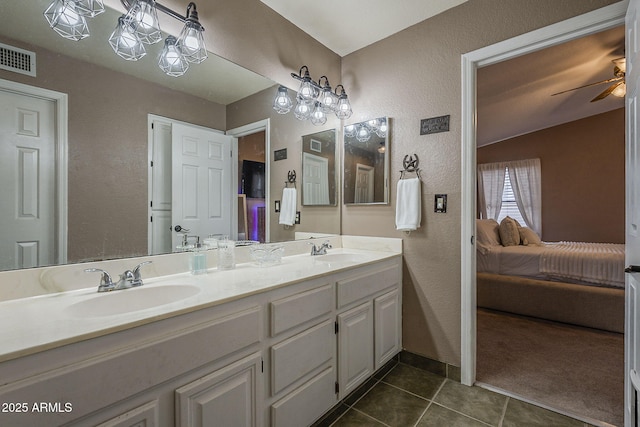 ensuite bathroom featuring tile patterned flooring, a sink, visible vents, and connected bathroom