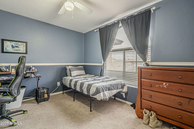 bedroom featuring a textured wall, carpet, a ceiling fan, and baseboards