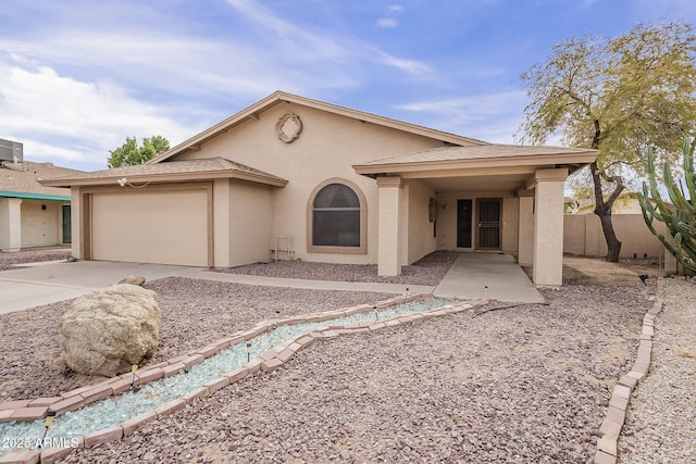 view of front of house featuring stucco siding, a shingled roof, fence, a garage, and driveway