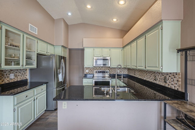 kitchen with visible vents, lofted ceiling, appliances with stainless steel finishes, green cabinets, and a sink