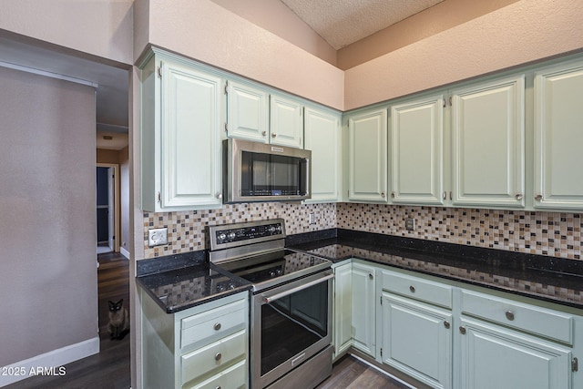 kitchen with stainless steel appliances, dark wood-type flooring, and decorative backsplash