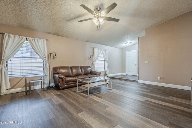 living area with vaulted ceiling, dark wood-style flooring, a textured ceiling, and baseboards