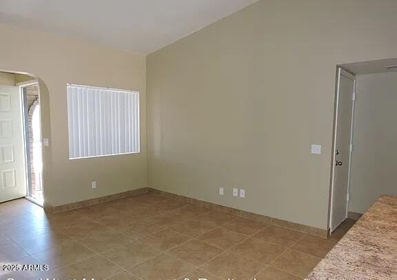 unfurnished room featuring vaulted ceiling