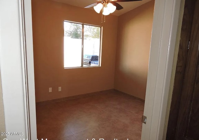 tiled spare room with ceiling fan