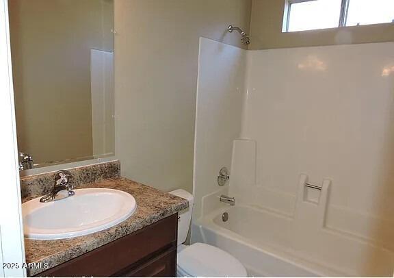 full bathroom featuring toilet, vanity, and  shower combination