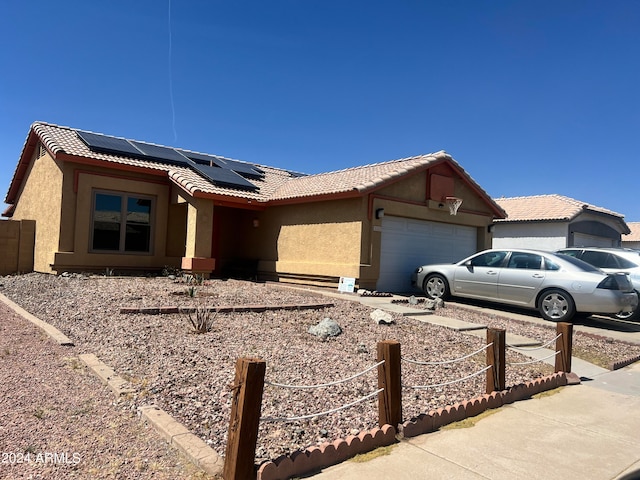 view of front of house with a garage and solar panels