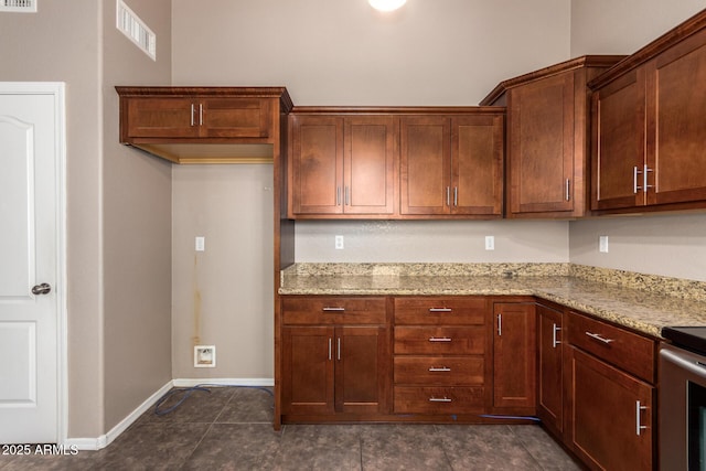 11352 E Dartmouth St, Mesa, AZ 85207 - kitchen with light stone counters, range, and dark tile patterned flooring