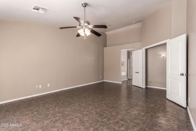 11352 E Dartmouth St, Mesa, AZ 85207 - unfurnished bedroom featuring a high ceiling, dark tile patterned flooring, and a ceiling fan