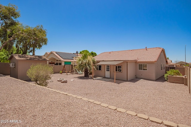 11352 E Dartmouth St, Mesa, AZ 85207 - back of house featuring a fenced backyard, a patio, a tiled roof, stucco siding, and a storage shed