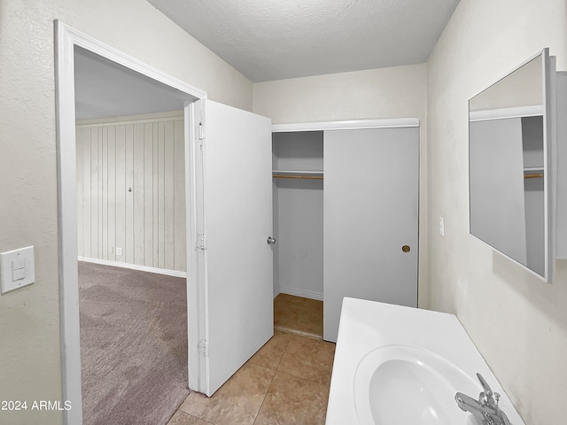 bathroom featuring sink, a textured ceiling, and tile patterned flooring