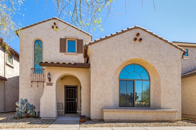 mediterranean / spanish-style house with a tiled roof and stucco siding