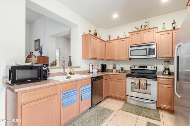 kitchen featuring light tile patterned floors, a sink, light brown cabinetry, light countertops, and stainless steel appliances