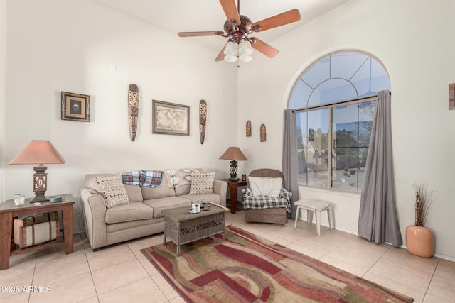 living room featuring light tile patterned floors, a ceiling fan, and a towering ceiling