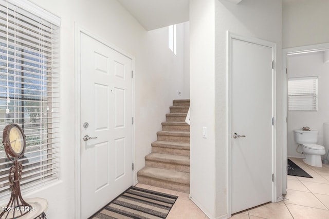 entrance foyer with light tile patterned floors and stairs