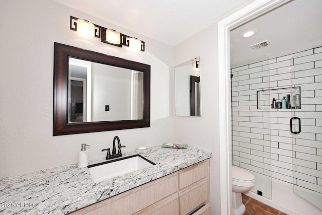 bathroom with toilet, vanity, tile patterned floors, and walk in shower