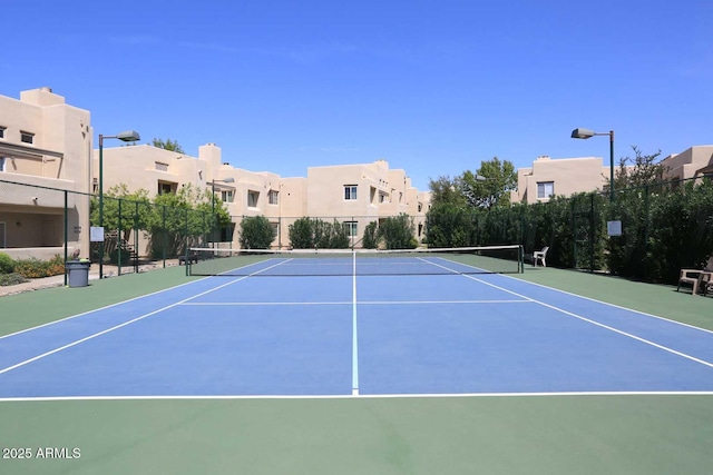 view of tennis court featuring a residential view, community basketball court, and fence